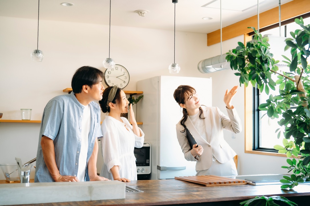 キッチンのある住宅を見学しながら話す3人