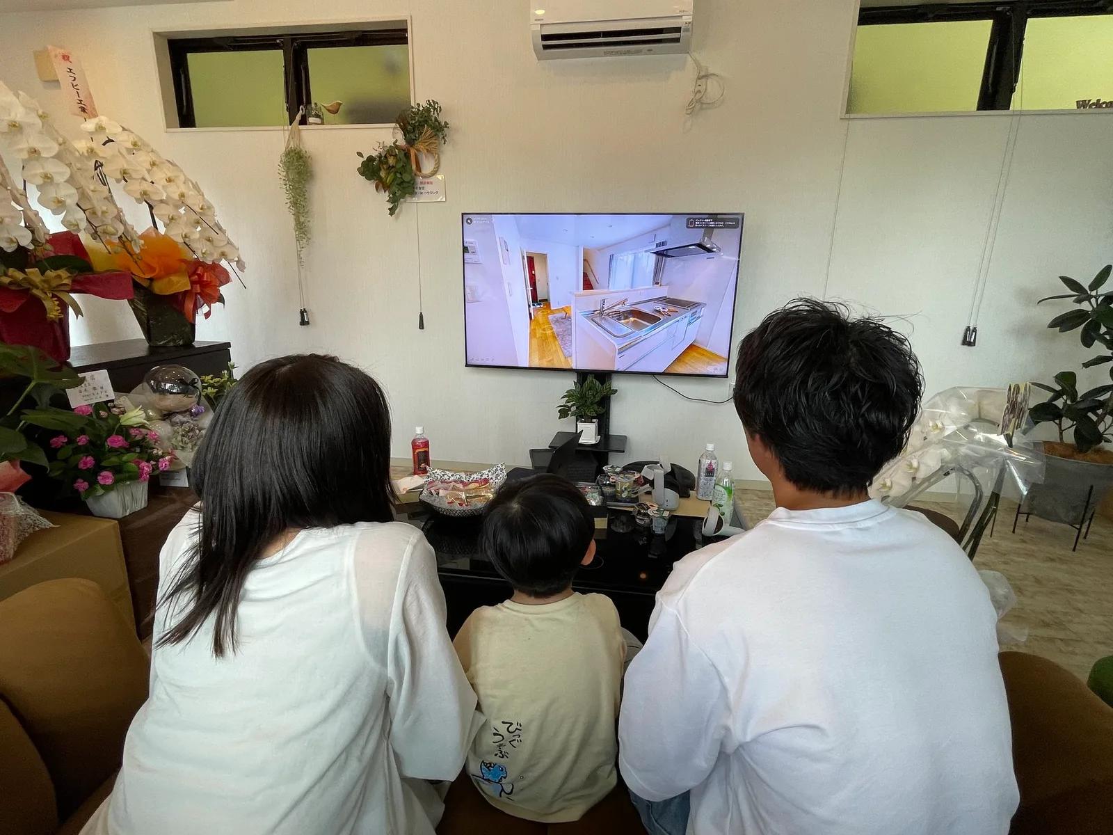 モニターに映した住宅をVRで見比べている家族