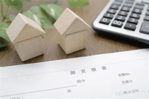 住宅の模型と電卓、見積書