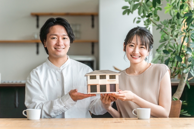 住宅の模型を手にしたIEKAKEのスタッフ2名