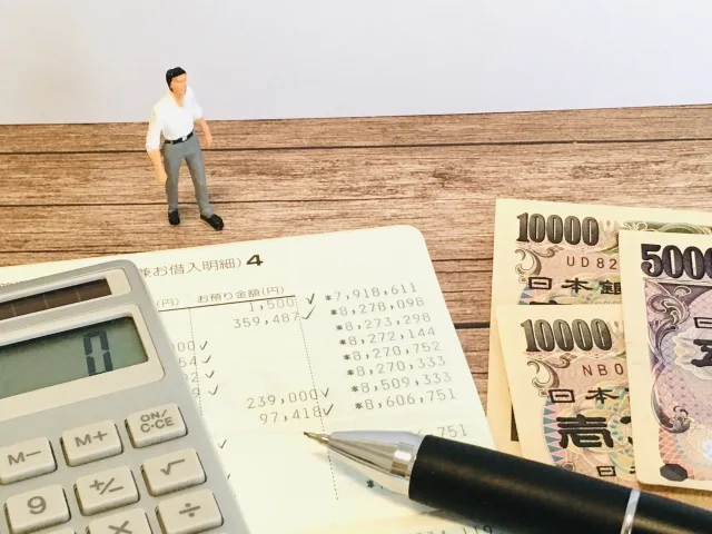 電卓と紙幣、住宅資金を試算しているイメージ